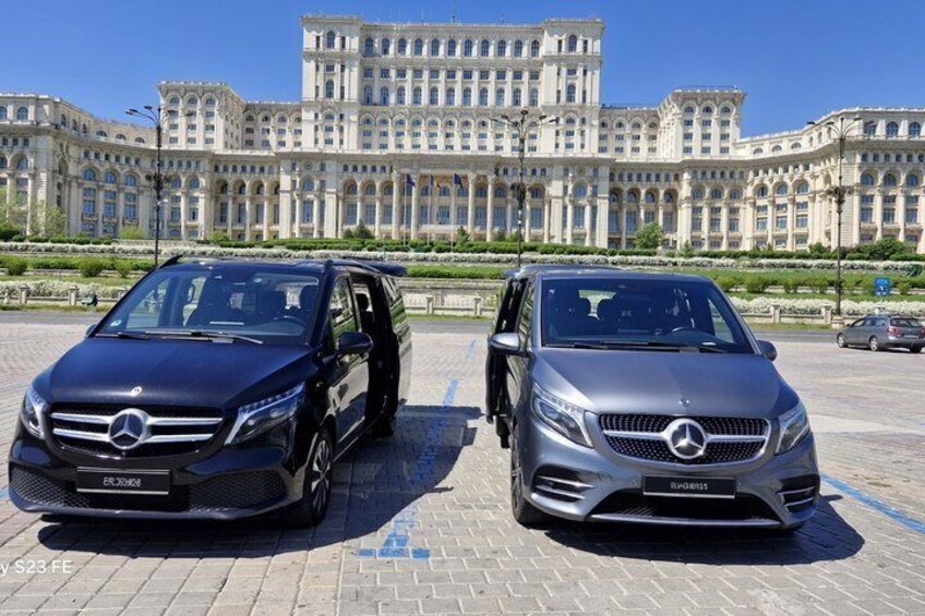 Två Mercedes-Benz-bilar parkerade framför en stor, utsmyckad byggnad. 2