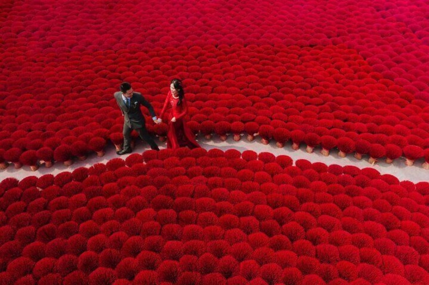 Ett par promenerar genom ett fält med röda blommor. 5