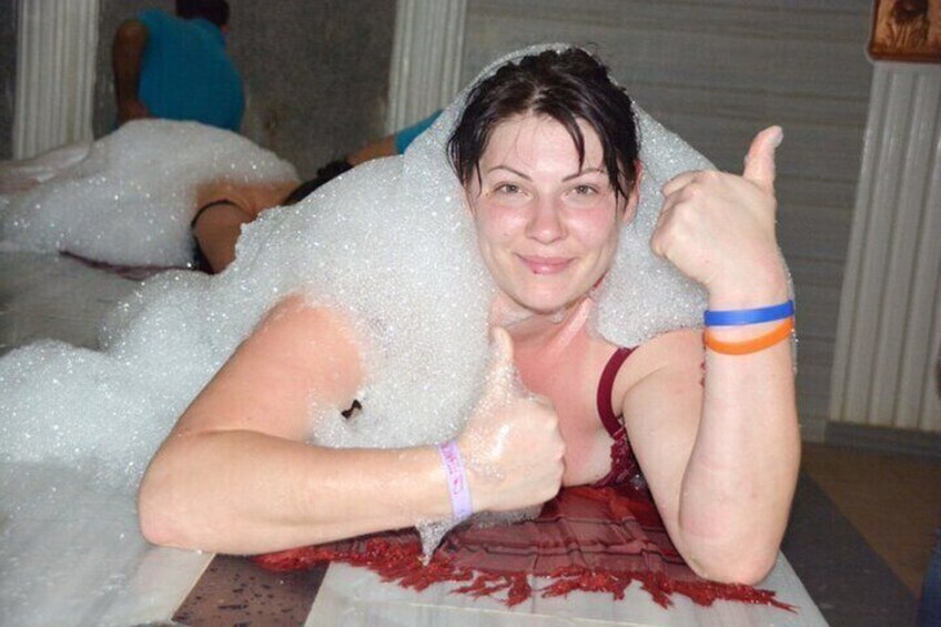 A person surrounded by foam, giving a thumbs up. 1