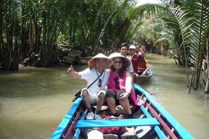 A group of people in a boat on a river surrounded by palm trees. 5