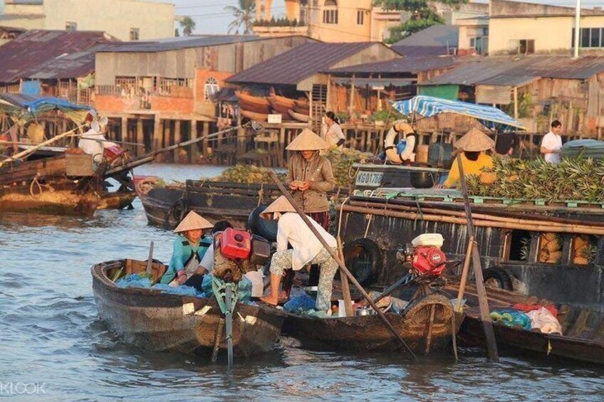 People on boats in a waterway, some wearing conical hats, with buildings in the background. 4
