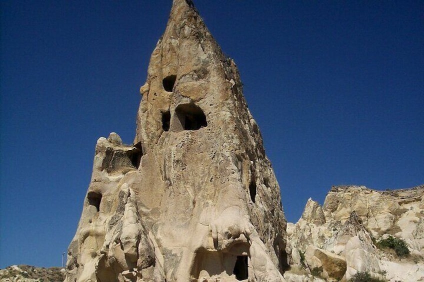 A tall, narrow rock formation with multiple holes. 2