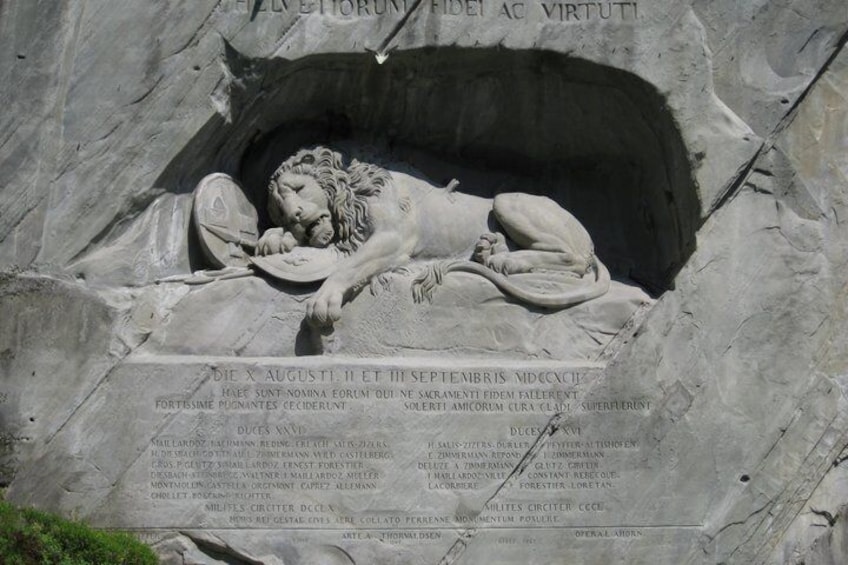 Un monumento de piedra con un relieve de una figura reclinada, rodeado de inscripciones y nombres. 4