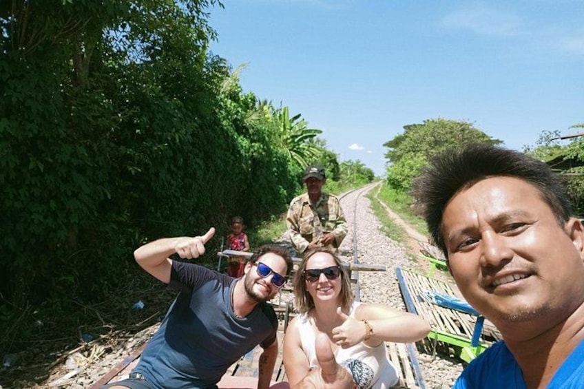 A group of people on a dirt road with greenery on both sides. 1