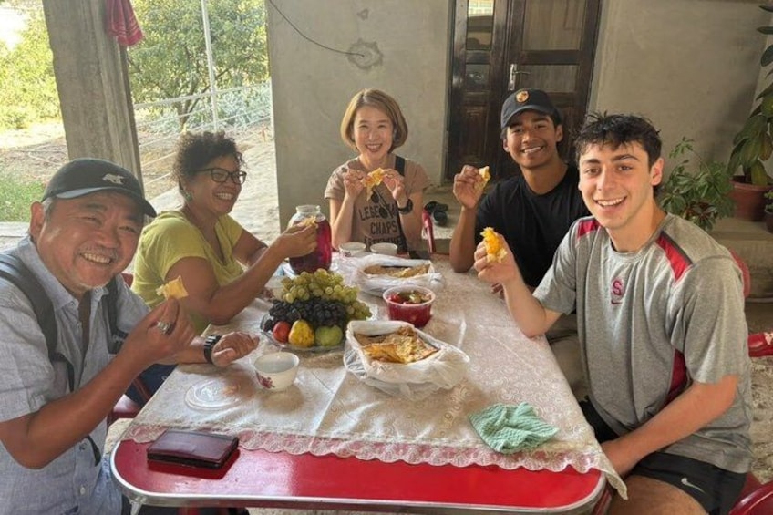 Un groupe de personnes est assis à une table, devant de la nourriture et des boissons. 2