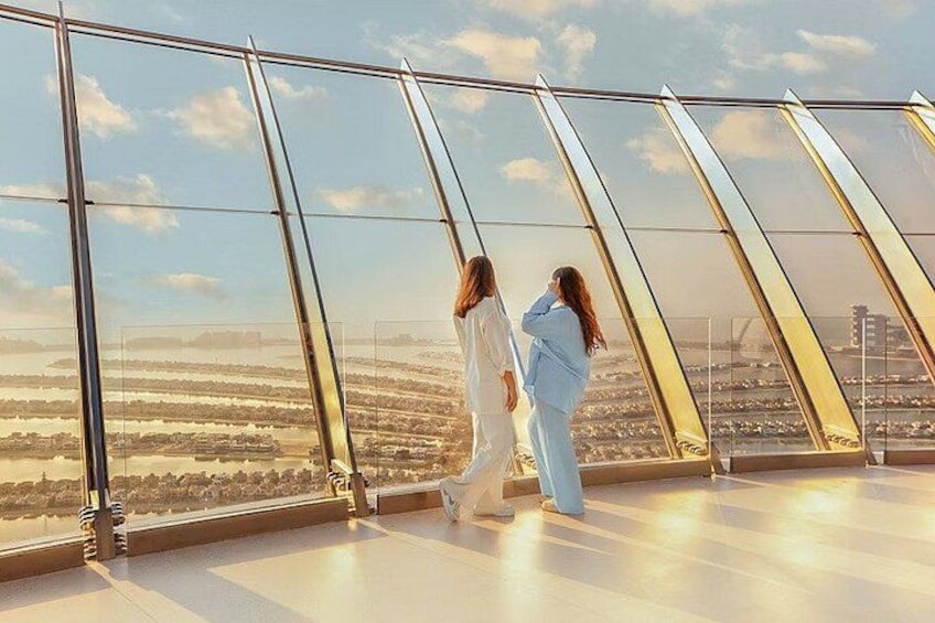 Deux personnes se promènent sur un plancher de verre, avec une vue sur le paysage urbain. 3