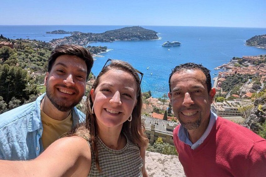 Three people taking a selfie with a coastal landscape in the background. 2