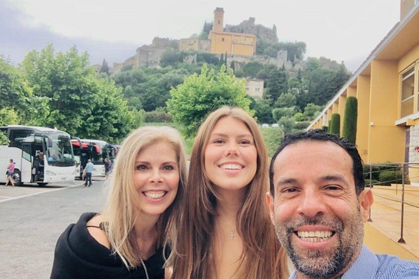 Three people in front of a historic building with a castle in the background. 3