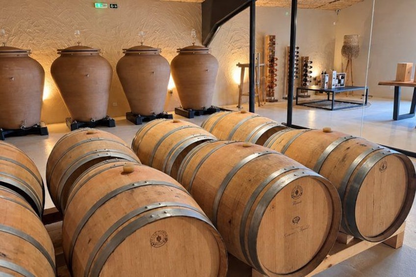 Large wooden barrels and clay pots in a room with a modern interior design. 3
