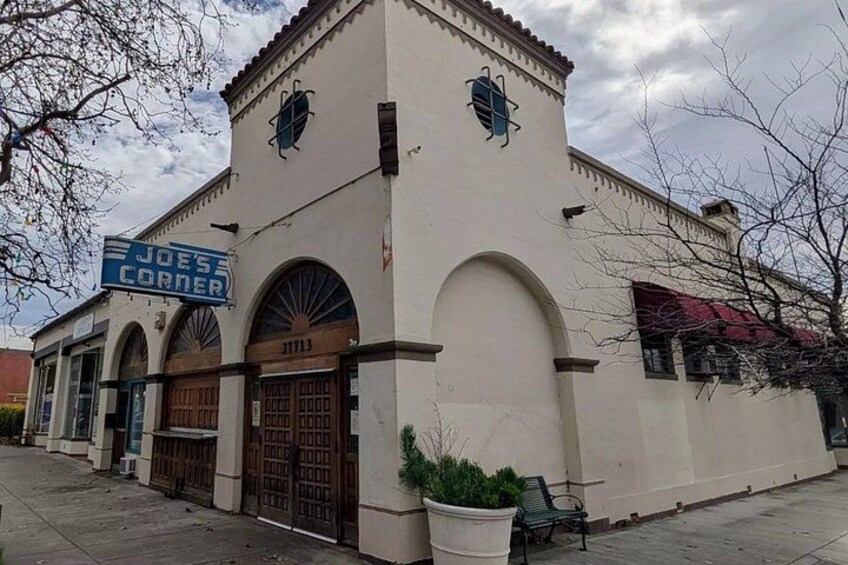 A building with a sign reading 'JOE'S CORNER' and a large arched entrance. 2