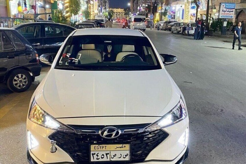 A white Hyundai car with a visible license plate in Egypt. 4