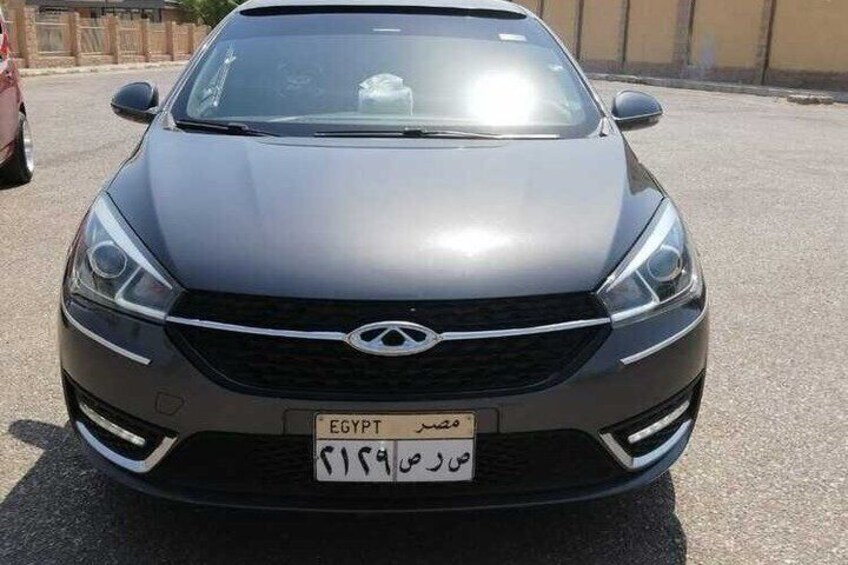 A gray car with a visible license plate and a logo on the front. 3