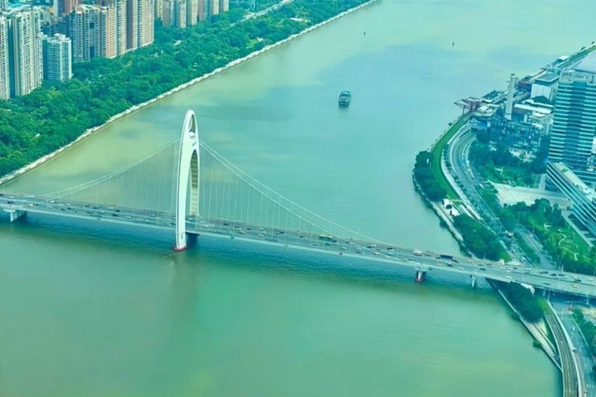 Een brede witte brug over een rivier, omgeven door groen en stadsgebouwen. 5