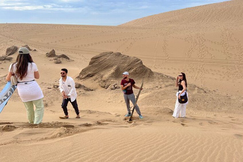 A desert landscape with sand dunes and a group of people. 4