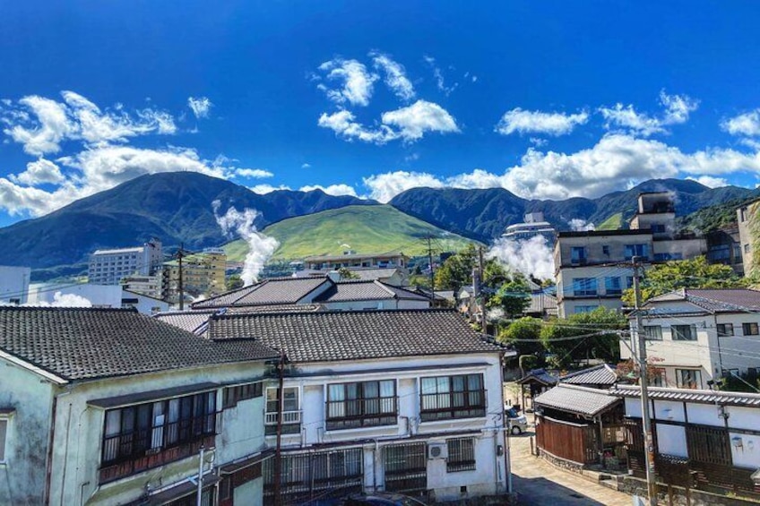 Une ville aux bâtiments traditionnels, avec une montagne en arrière-plan et un ciel dégagé. 4