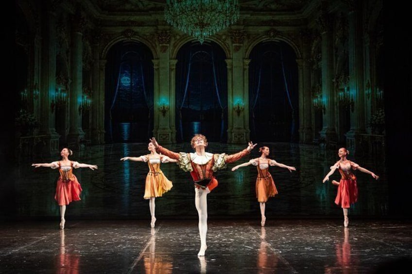 Uno spettacolo di balletto in un teatro sontuoso e ricco di decorazioni, con colonne e lampadari. 5