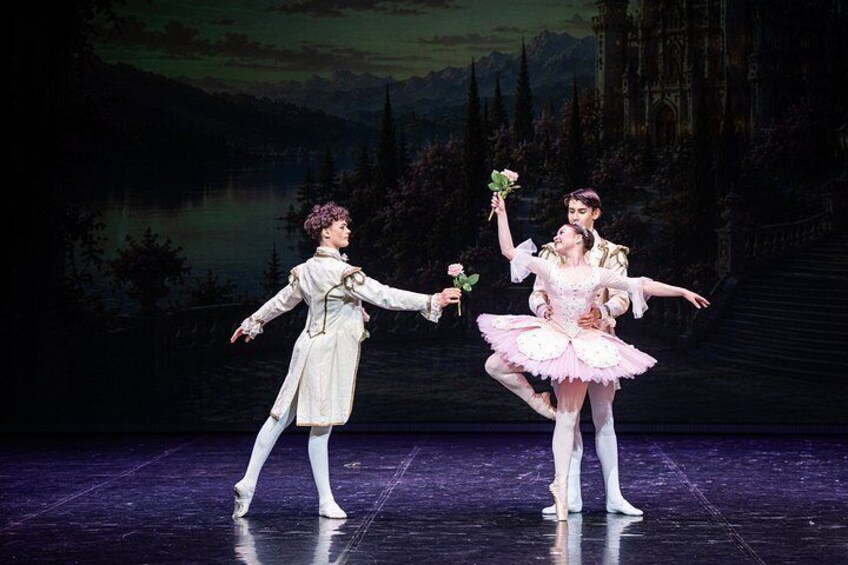 A ballet performance on stage with dancers in period costumes. 3