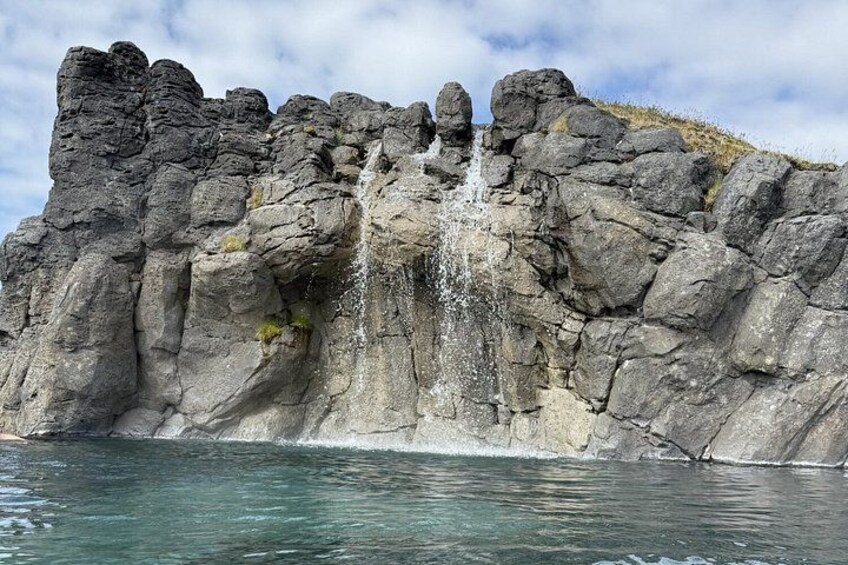 A rocky cliff with a waterfall. 3