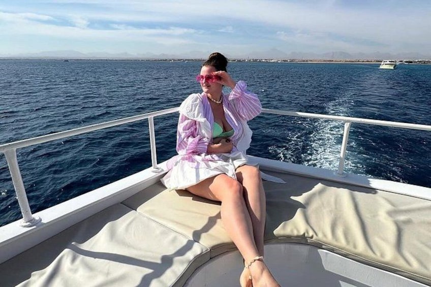 A person sitting on a boat with a view of the sea and a distant shoreline. 4