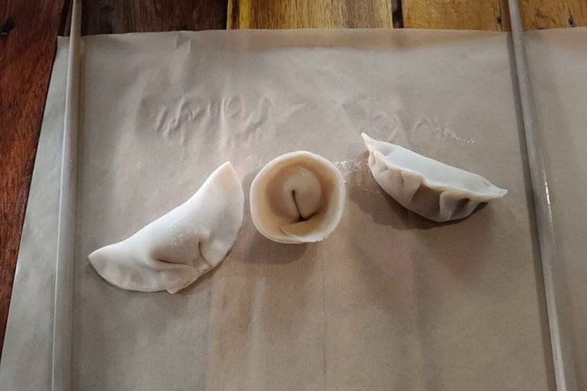 Three dumplings on a baking sheet. 5