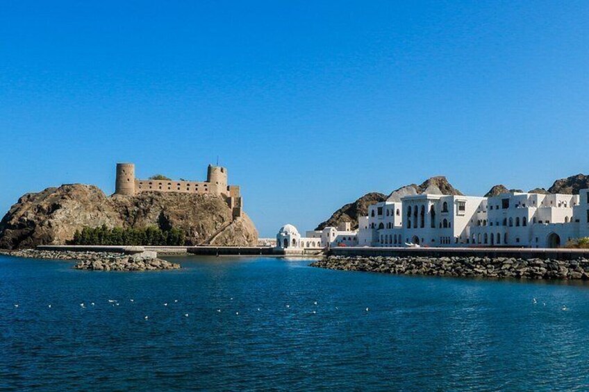 Un pueblo costero con un castillo en un promontorio rocoso y edificios blancos con cúpulas. 4