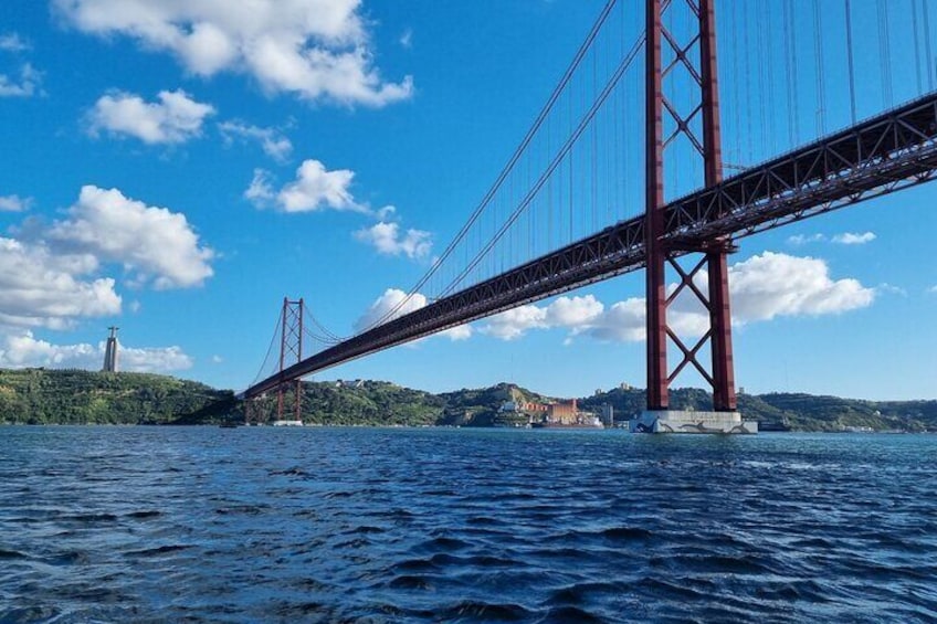 Un ampio ponte rosso che attraversa un corso d'acqua, con delle colline sullo sfondo. 3