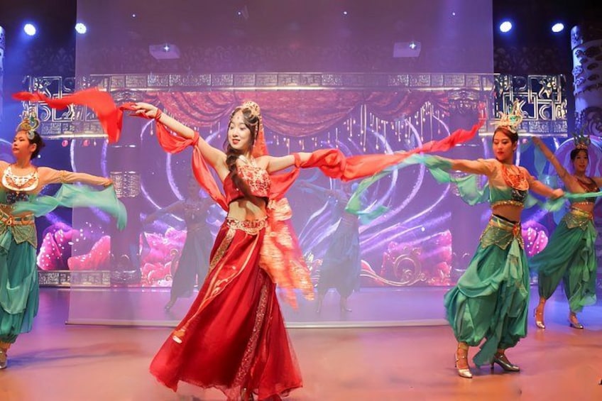 A stage with dancers in traditional costumes performing a dance. 5