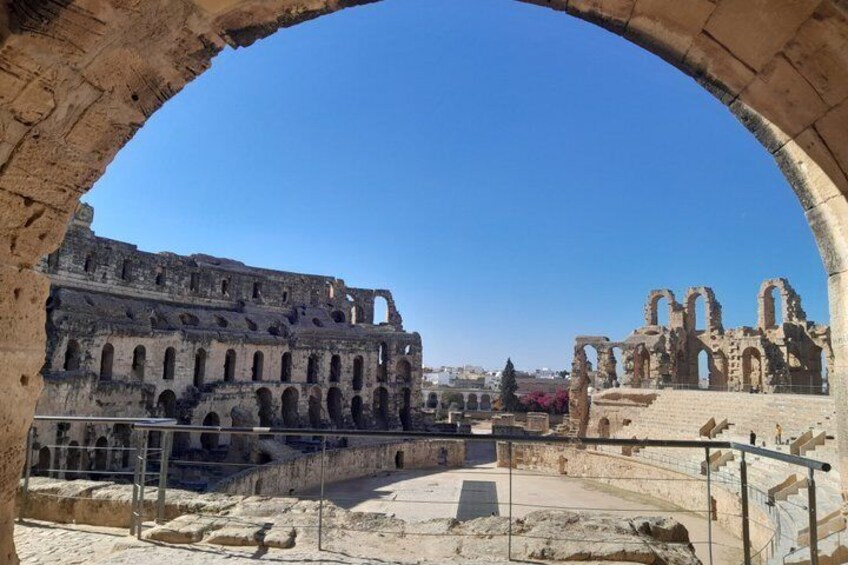 Ancient ruins with arches and columns, including a large amphitheater and a smaller structure with arches. 2