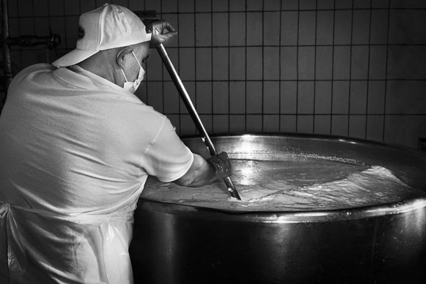 Eine Person in Uniform schabt oder reinigt mit einem langen Werkzeug eine große Metallfläche. 5