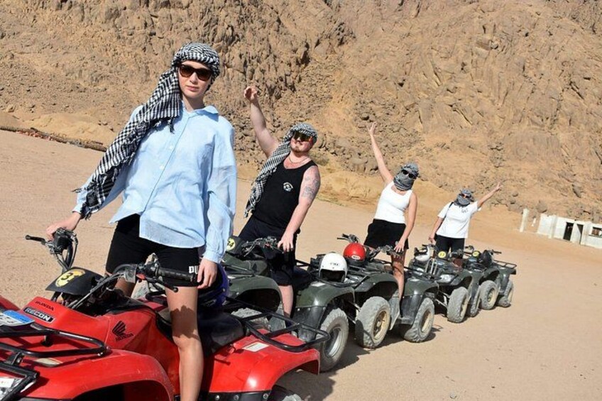 A group of people on ATVs in a desert setting. 3