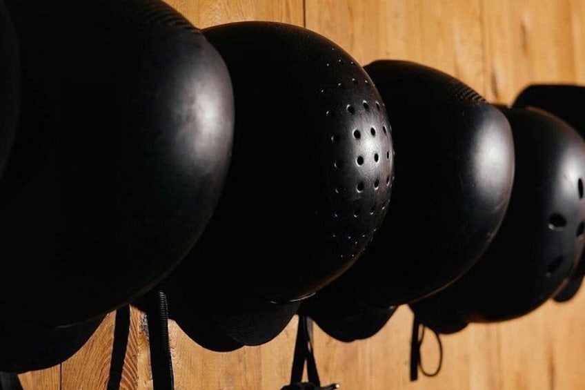 A row of black helmets on a wooden surface. 4