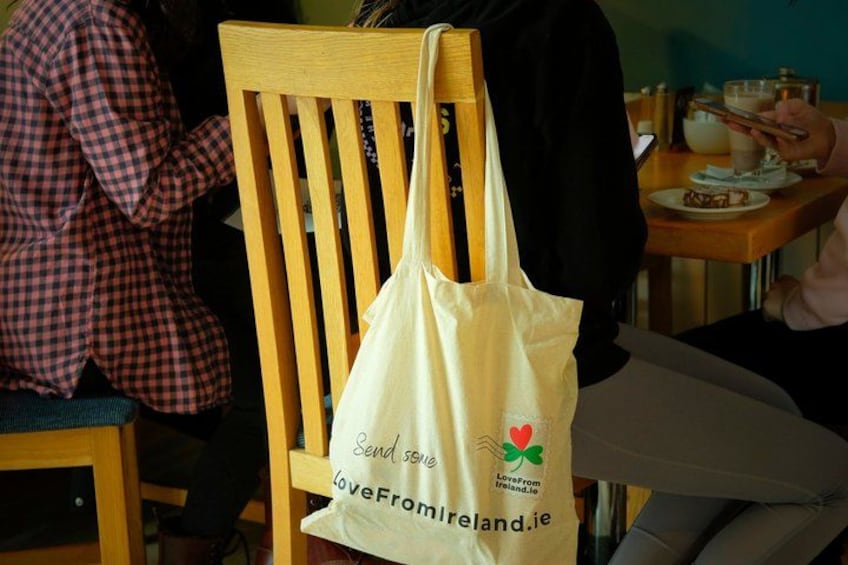 A wooden chair with a white tote bag hanging on the backrest. 2