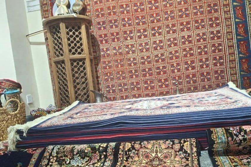 Un'esposizione di tessuti finemente decorati, una struttura in legno a griglia e un muro decorato. 2