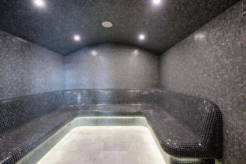 A spa with a tiled wall, a curved seating area, and a rectangular hot tub. 4