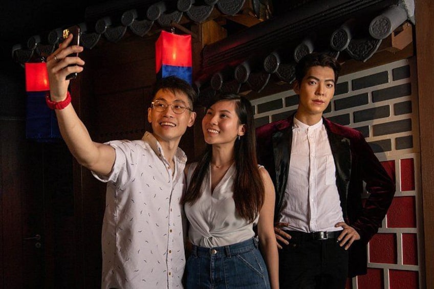 Three people taking a selfie in a room with traditional decor. 2