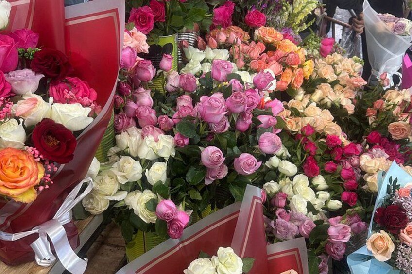 Una variedad de flores, incluyendo rosas y otras especies, exhibidas en ramos y arreglos florales. 2