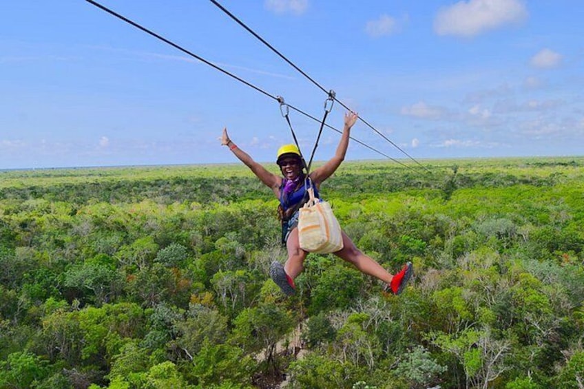 A person ziplining over a lush green landscape. 3