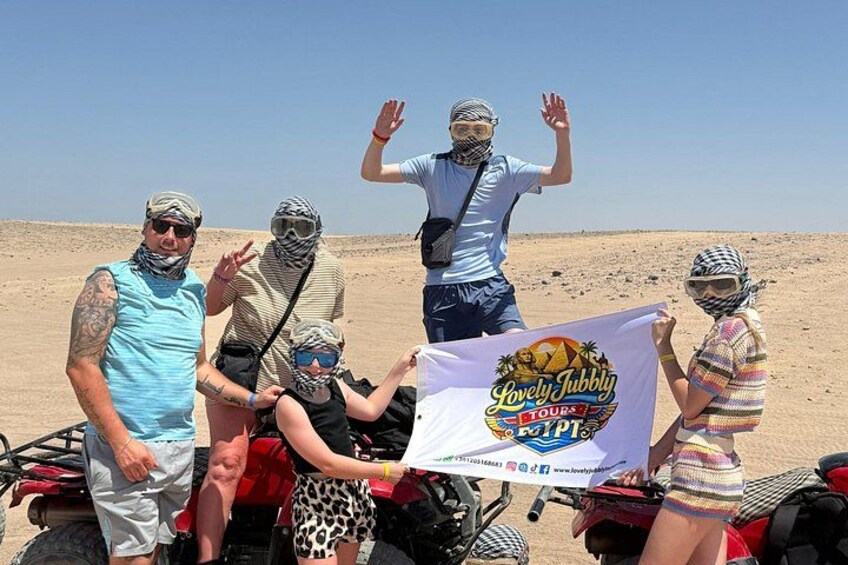 Un groupe de personnes à bord d’un véhicule tout-terrain sur une dune, dans un paysage désertique. 4