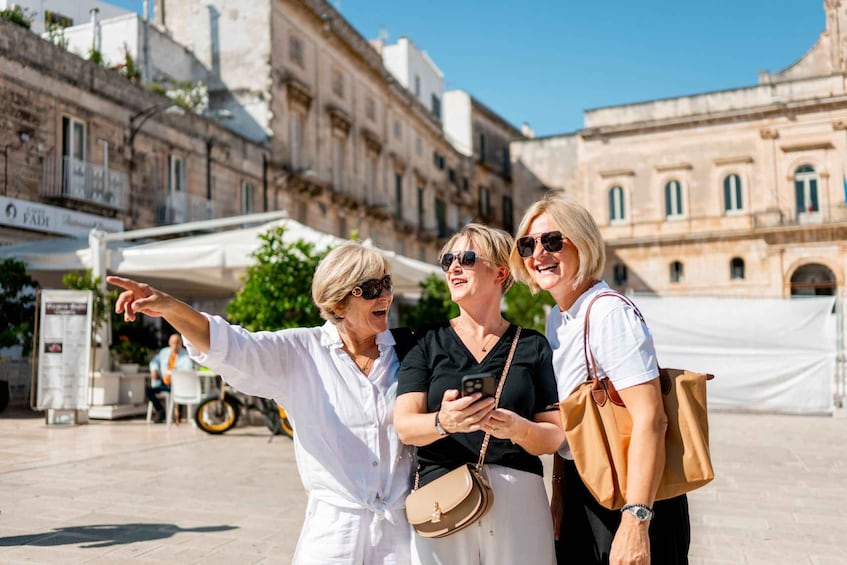 Three people taking a selfie in an urban setting with historical buildings in the background. 5