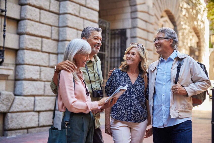 Four people walking on a stone-paved street with a building in the background. 2