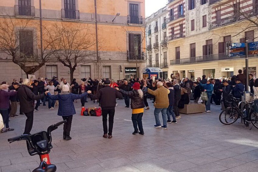 A group of people dancing in a public square. 3