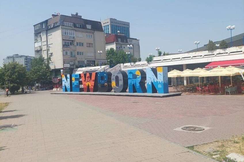 A mural with the word 'NEW' and a cityscape in the background. 3