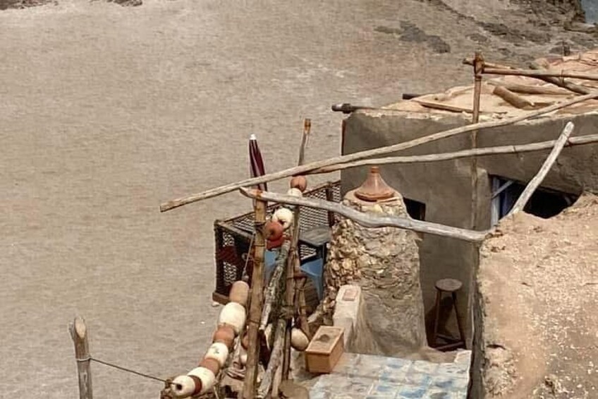 Una estructura rústica con una rueda hidráulica, una pequeña cabaña y un puente de madera. 3