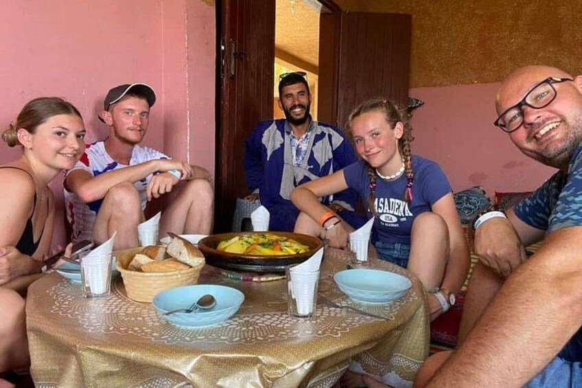 Un grupo de personas sentadas alrededor de una mesa con comida y bebidas. 4
