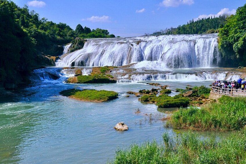 A waterfall, river, and a viewing platform with people. 1