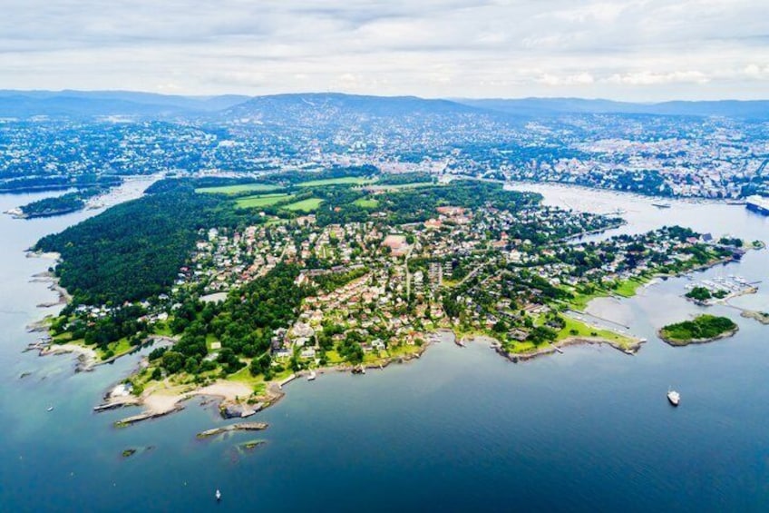Vue aérienne d’une ville côtière avec un centre urbain dense, une rivière et une végétation luxuriante environnante. 3