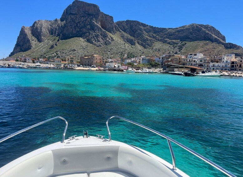 A boat on turquoise water with a rocky mountain in the background. 5