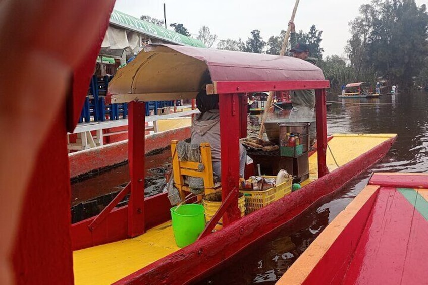 A colorful boat with a red canopy, a yellow deck, and a green bucket. 1