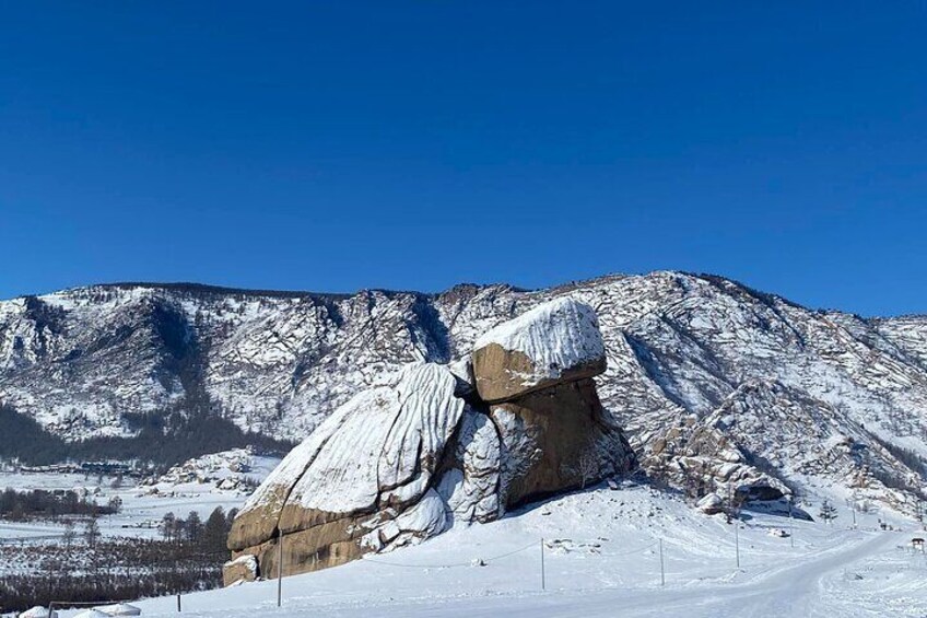 Una montaña cubierta de nieve con una gran formación rocosa. 3