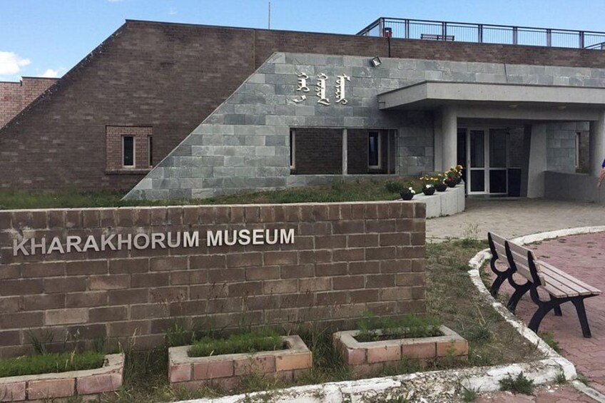 The entrance to the Kharaakhorum Museum with a brick wall and a sign. 5